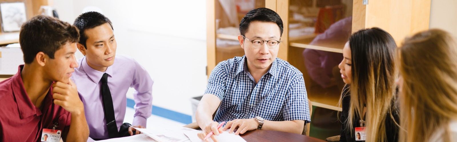 A sitting instructor teaches four students at a table